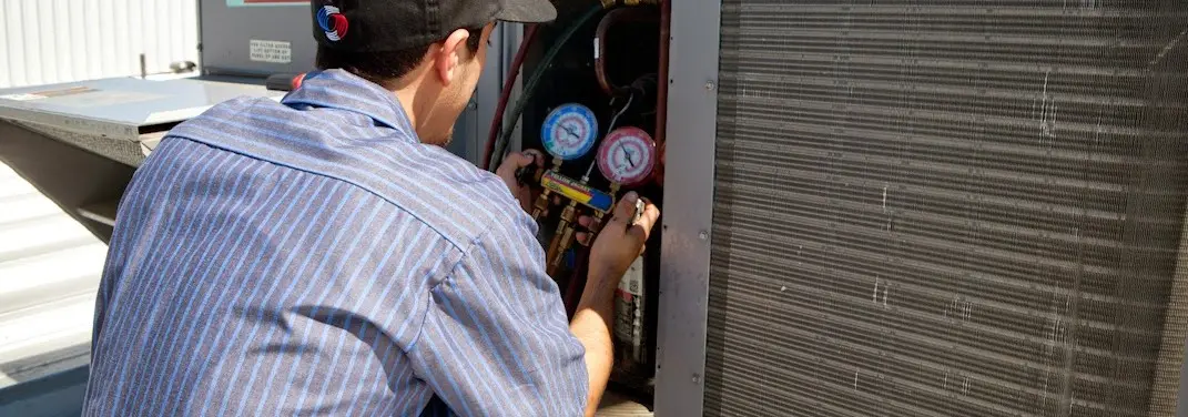HVAC technician servicing a condenser unit in Spotsylvania Courthouse